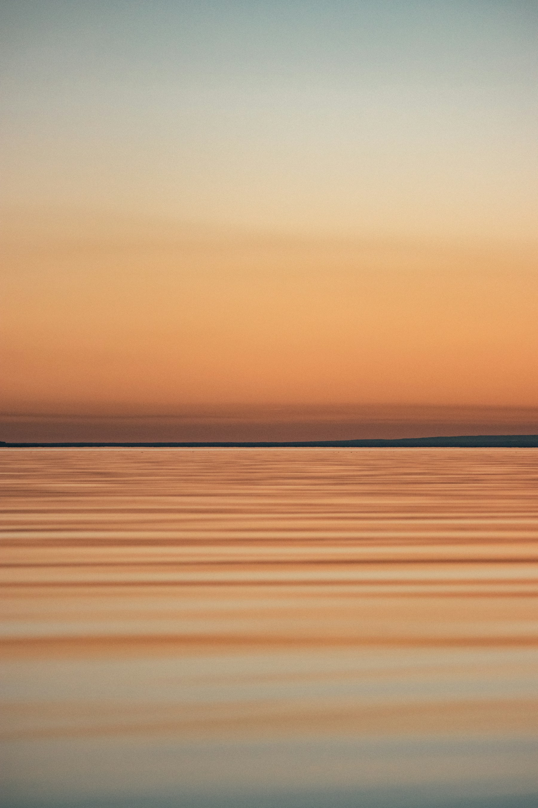 Mar tranquilo e horizonte ao pôr do sol